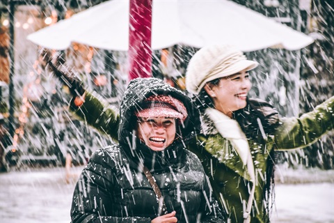 Two women laughing in the snow.